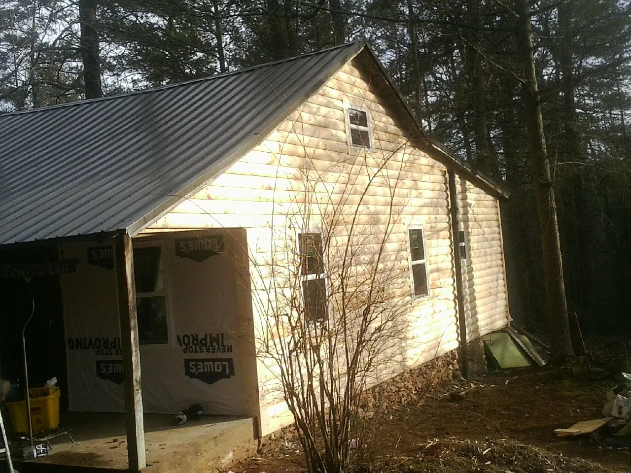 Log siding gable end under a dark metal roof edge in Longs
