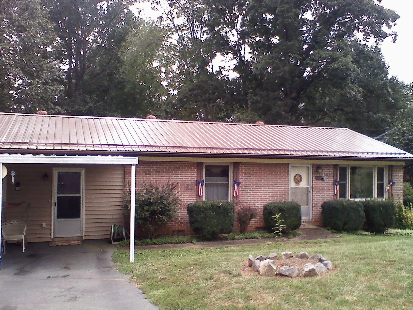 Bronze metal roof and carport on a brick ranch home — Roof Repair work by our crew in Longs